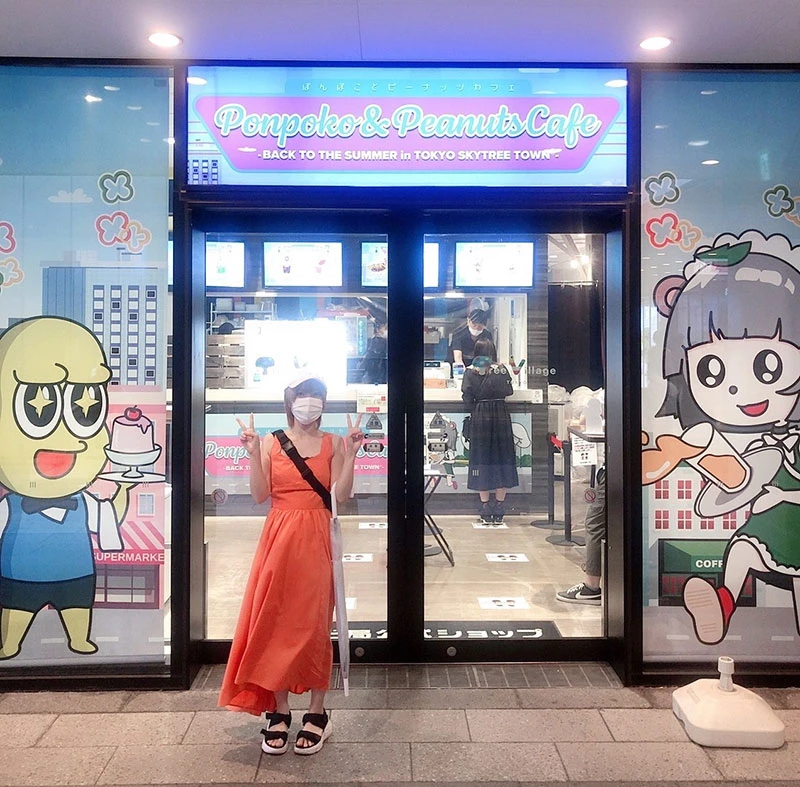 「Ponpoko & Peanuts Cafe」の前で写真を撮ってもらう筆者